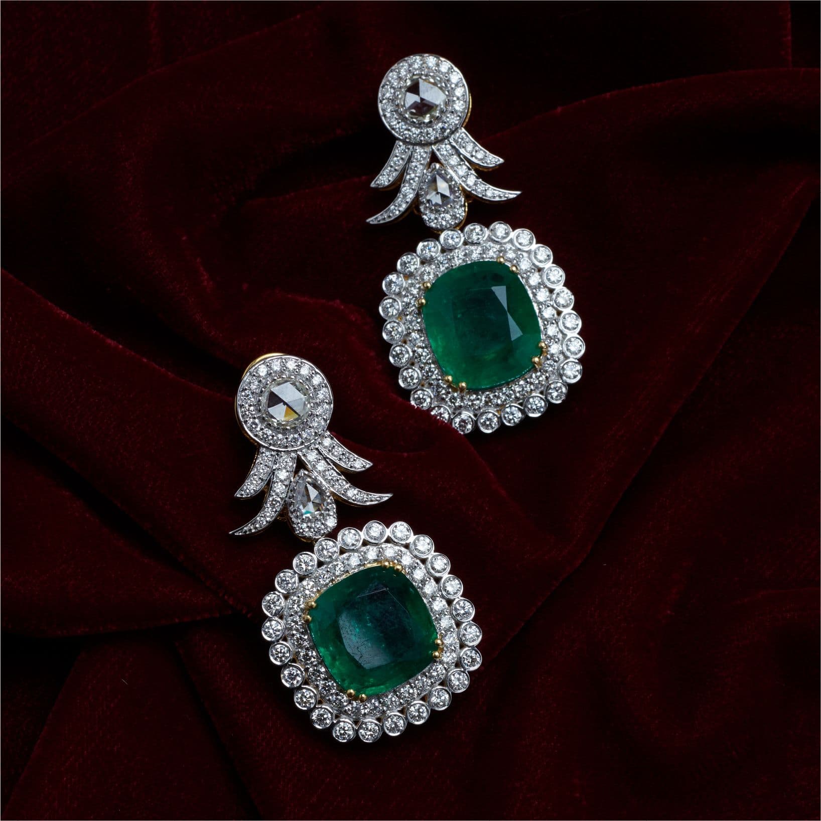Emerald and diamond earrings on red velvet