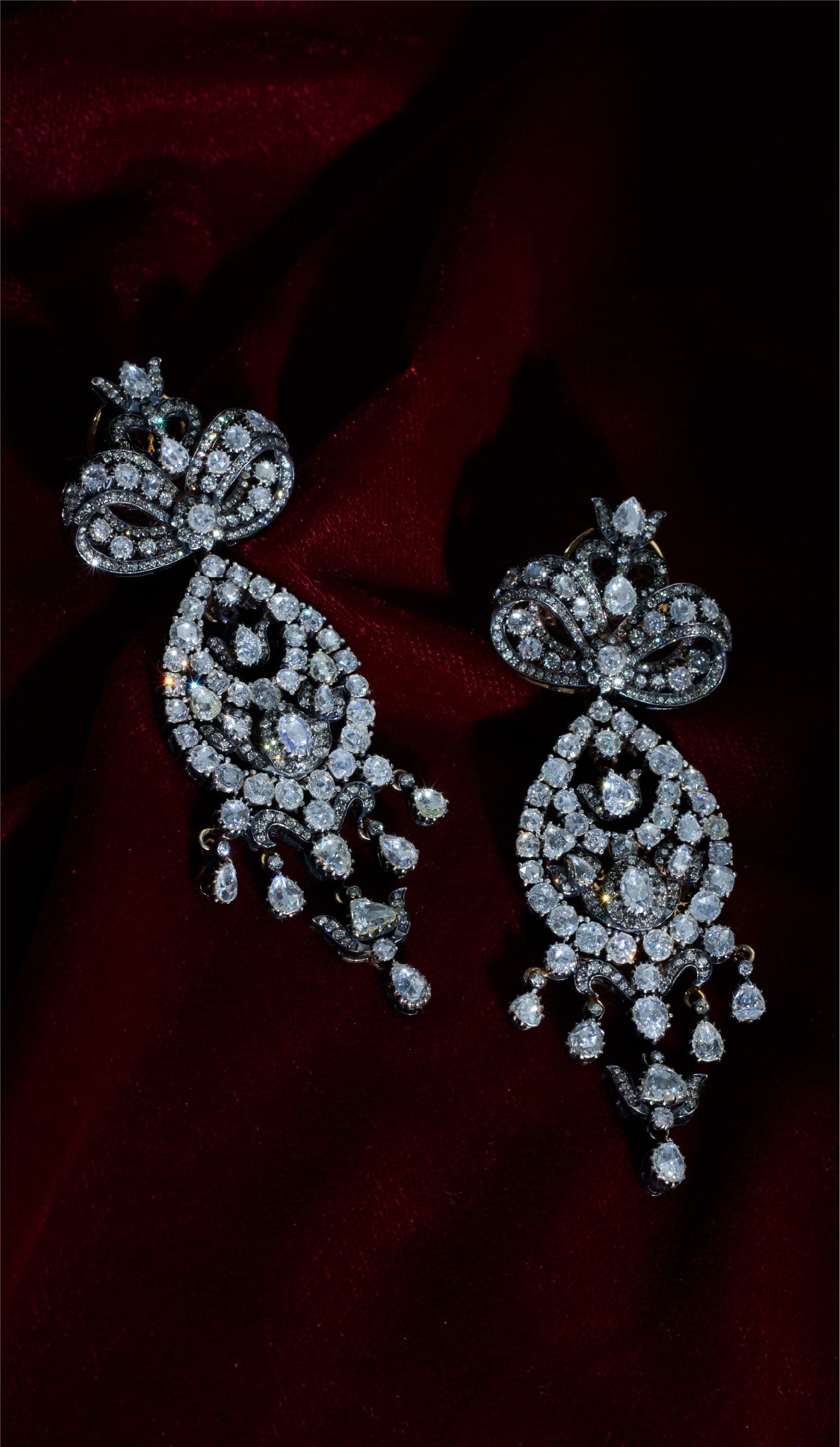 Diamond chandelier earrings on red velvet