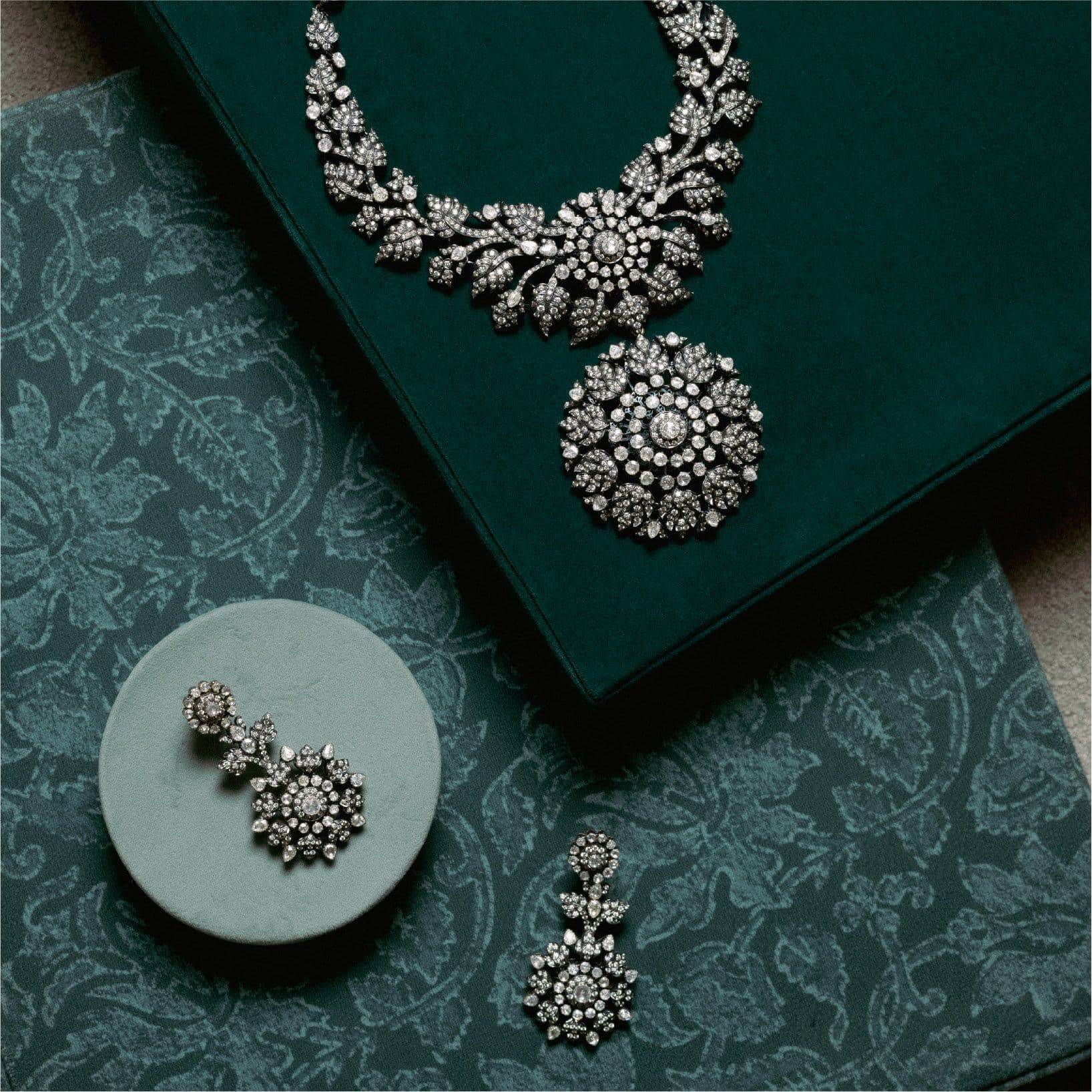 Diamond necklace and earrings on green silk