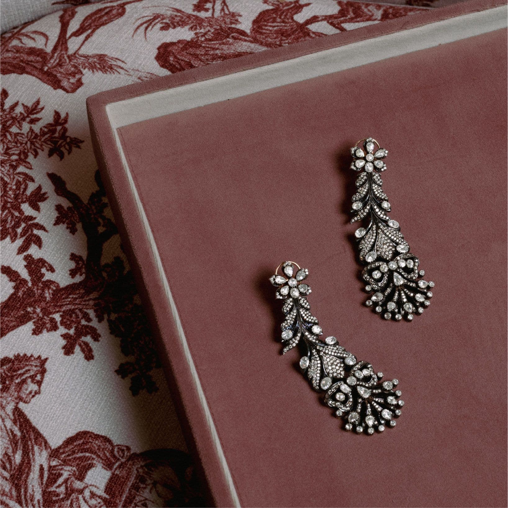 Diamond leaf earrings on a pink velvet box