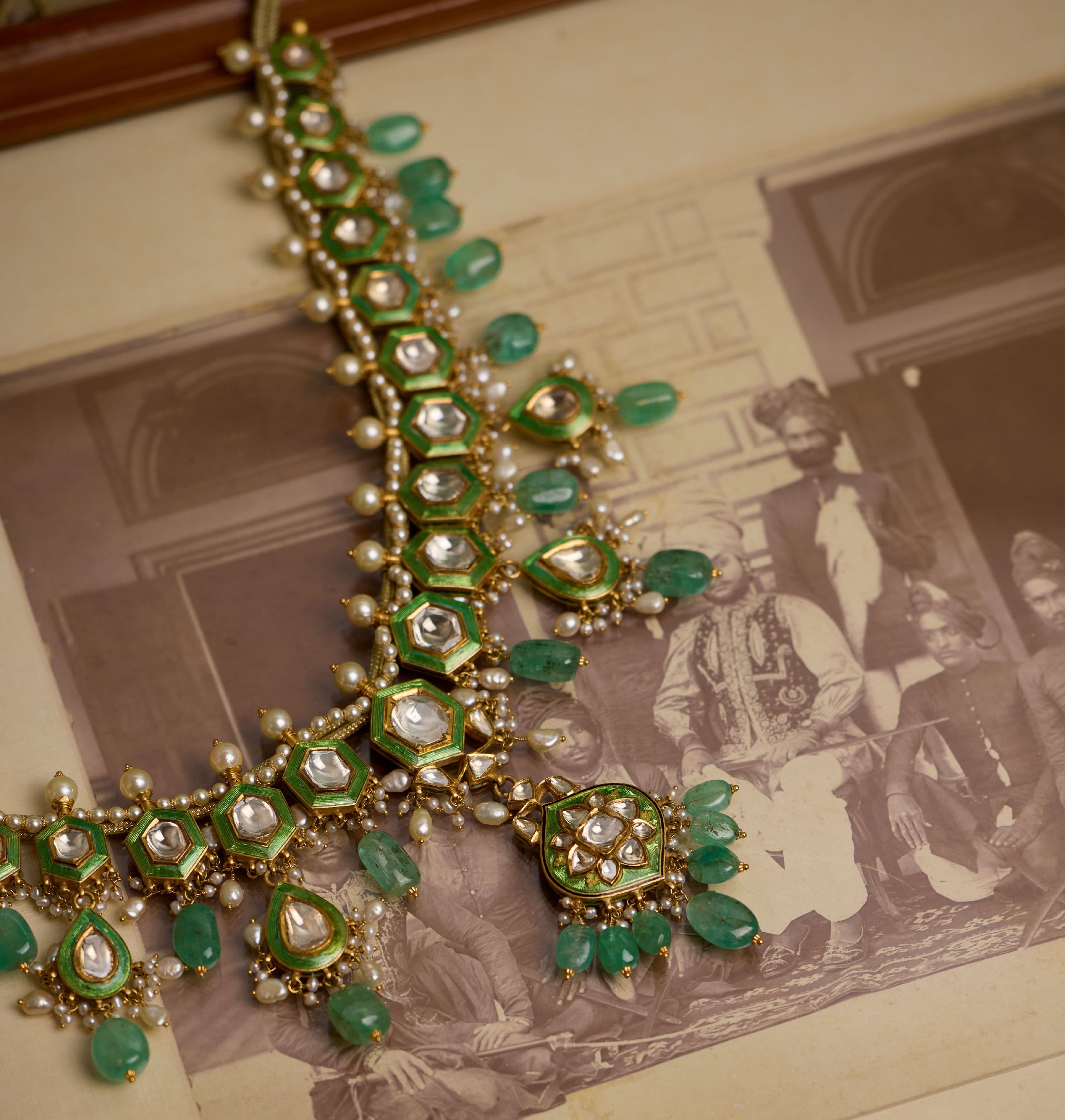 Emerald, pearl and polki haar laid over old photographs