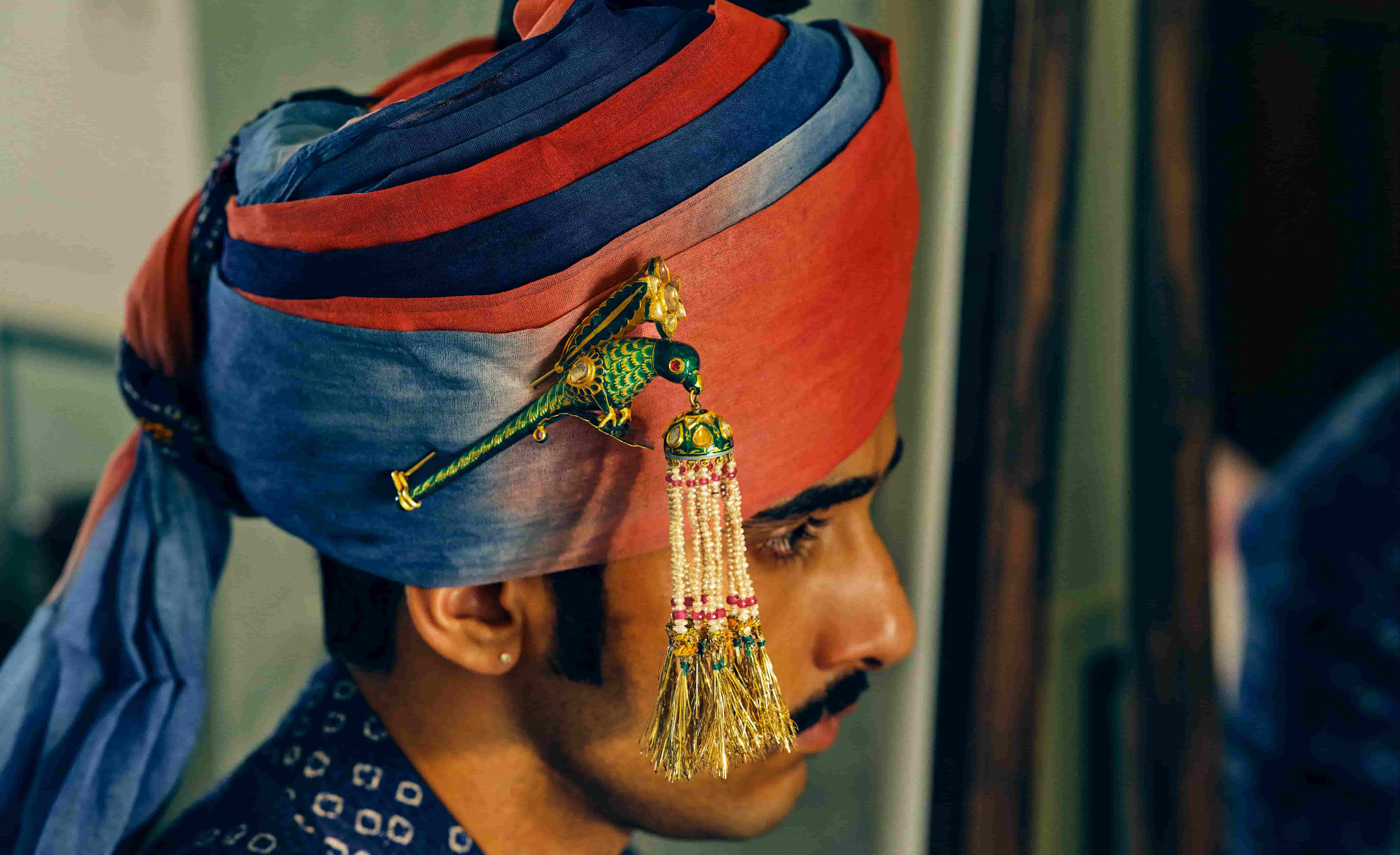 Mhaaro — close-up of orange and blue striped turban with parrot sarpech