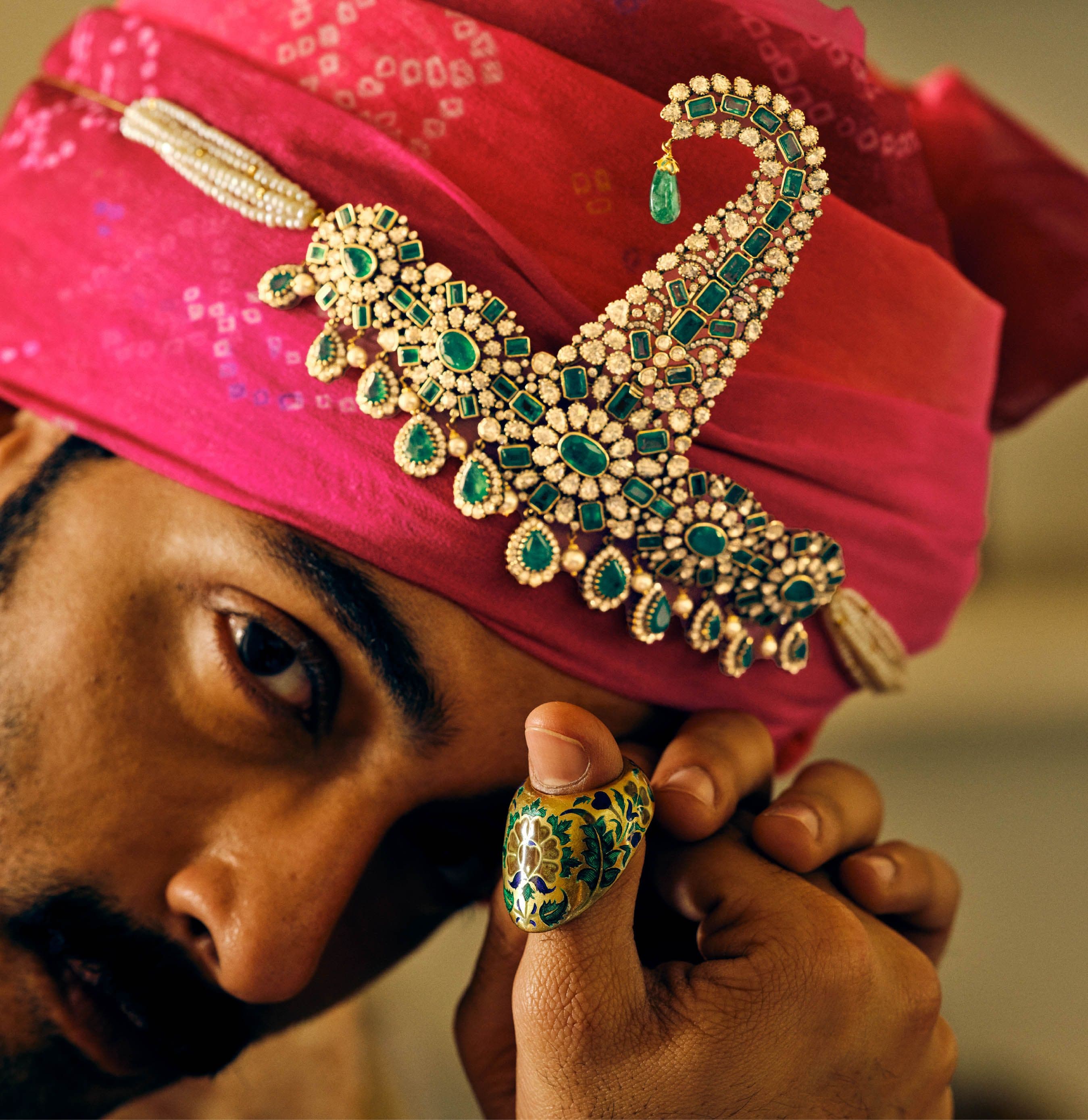 Emerald and polki sarpatti laid across a pink bandhani safa