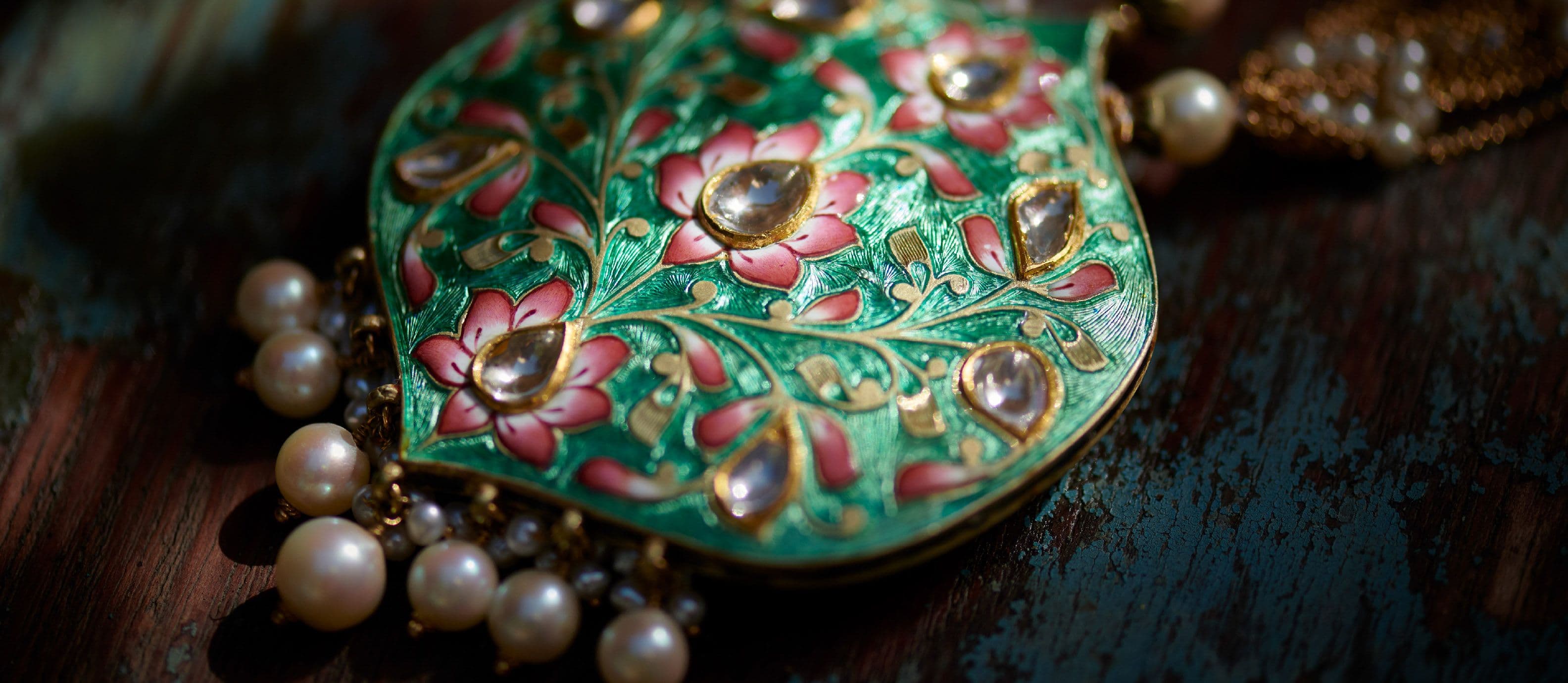 Green meenakari leaf pendant set with polki and hung with pearls