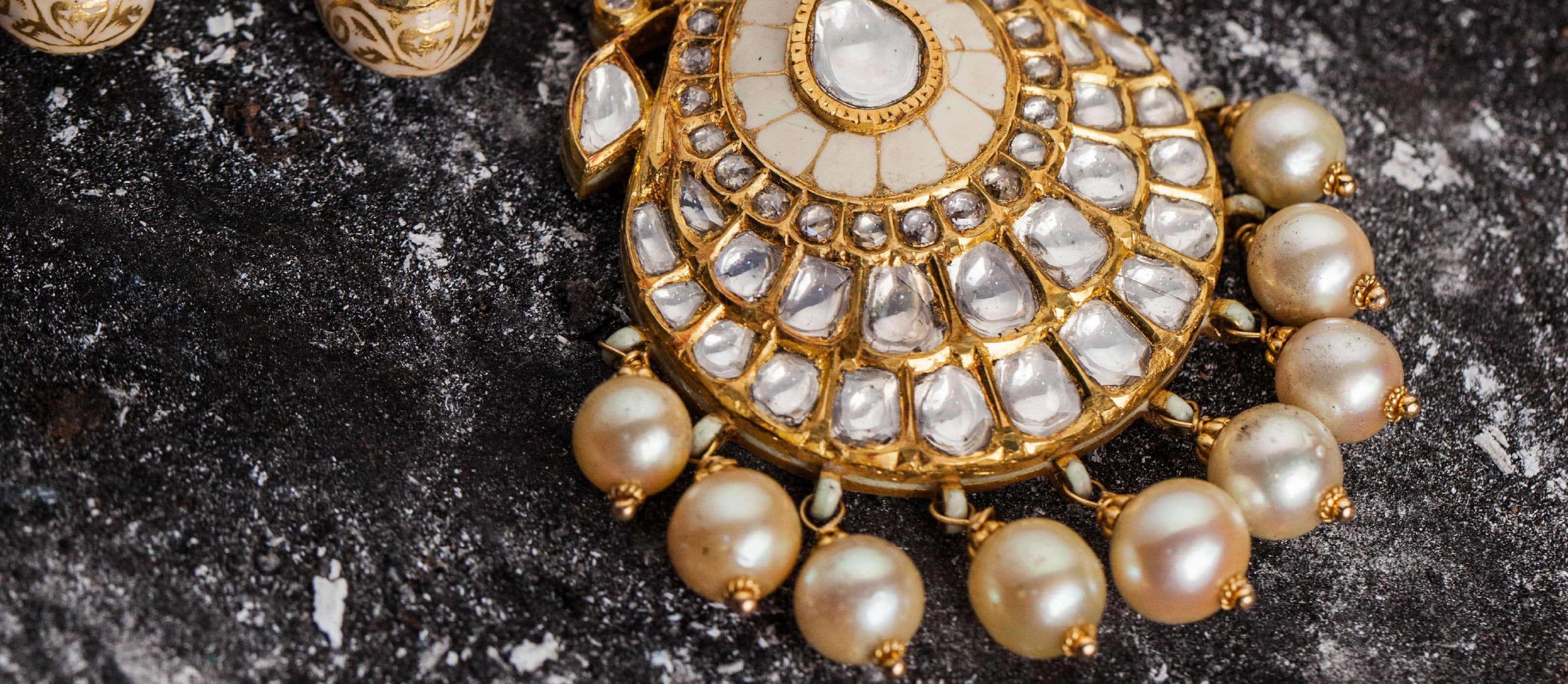 White enamel pendant set with polki and strung with pearls